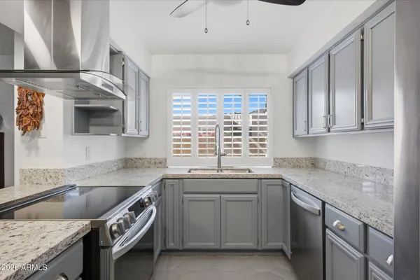 a kitchen with granite countertop a sink stainless steel appliances and cabinets