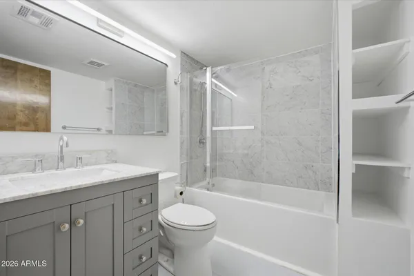 a bathroom with a bathtub shower sink vanity and toilet