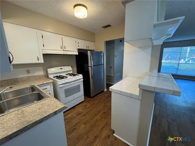 a kitchen with a sink stove and refrigerator