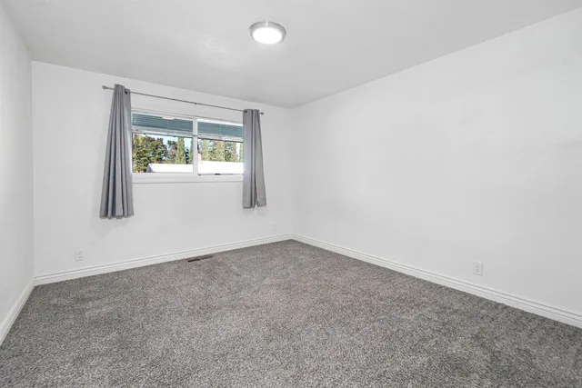 a view of an empty room with glass door and a window