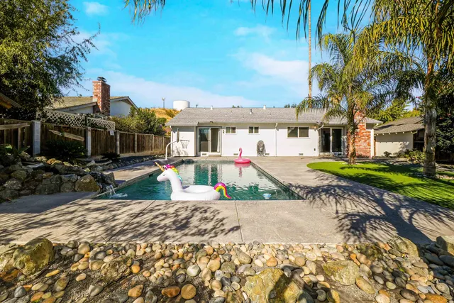 a swimming pool with outdoor seating and yard