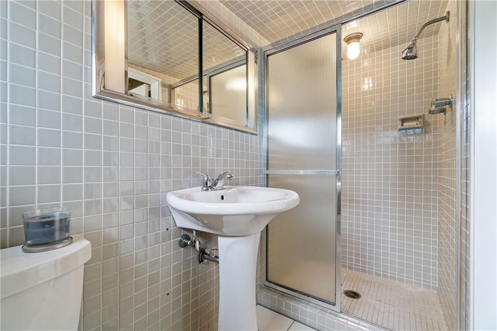 17 Penhurst Road Pittsburgh, PA 15202 - Photo 30 of 42 a bathroom with a shower a mirror and a sink