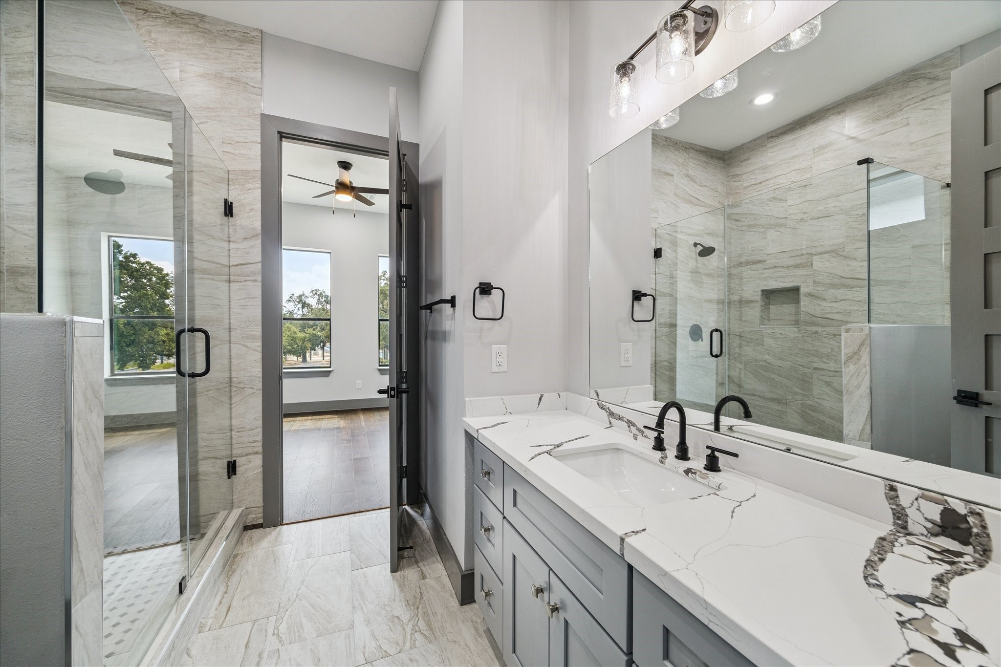 2323 Tuam Street Houston, TX 77004 - Photo 19 of 24 A glass-enclosed shower showcases sleek tile details, complemented by soft lighting that highlights the fresh, contemporary atmosphere.