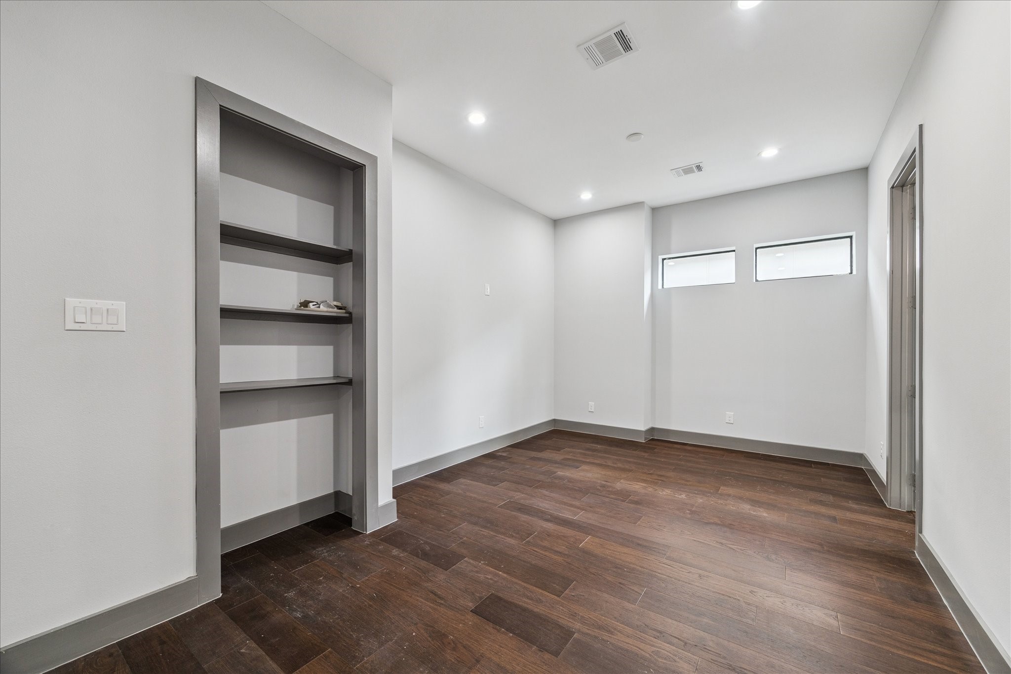 2323 Tuam Street Houston, TX 77004 - Photo 21 of 24 Flexible upstairs space offers endless possibilities, from a media room or playroom to a quiet home office, complete with custom built-in shelves and natural light from dual windows.