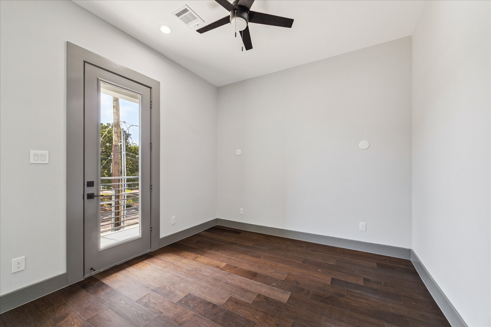 2323 Tuam Street Houston, TX 77004 - Photo 22 of 24 Versatile and bright, the secondary bedroom features wood flooring, neutral walls, and a glass door leading to a private balcony.