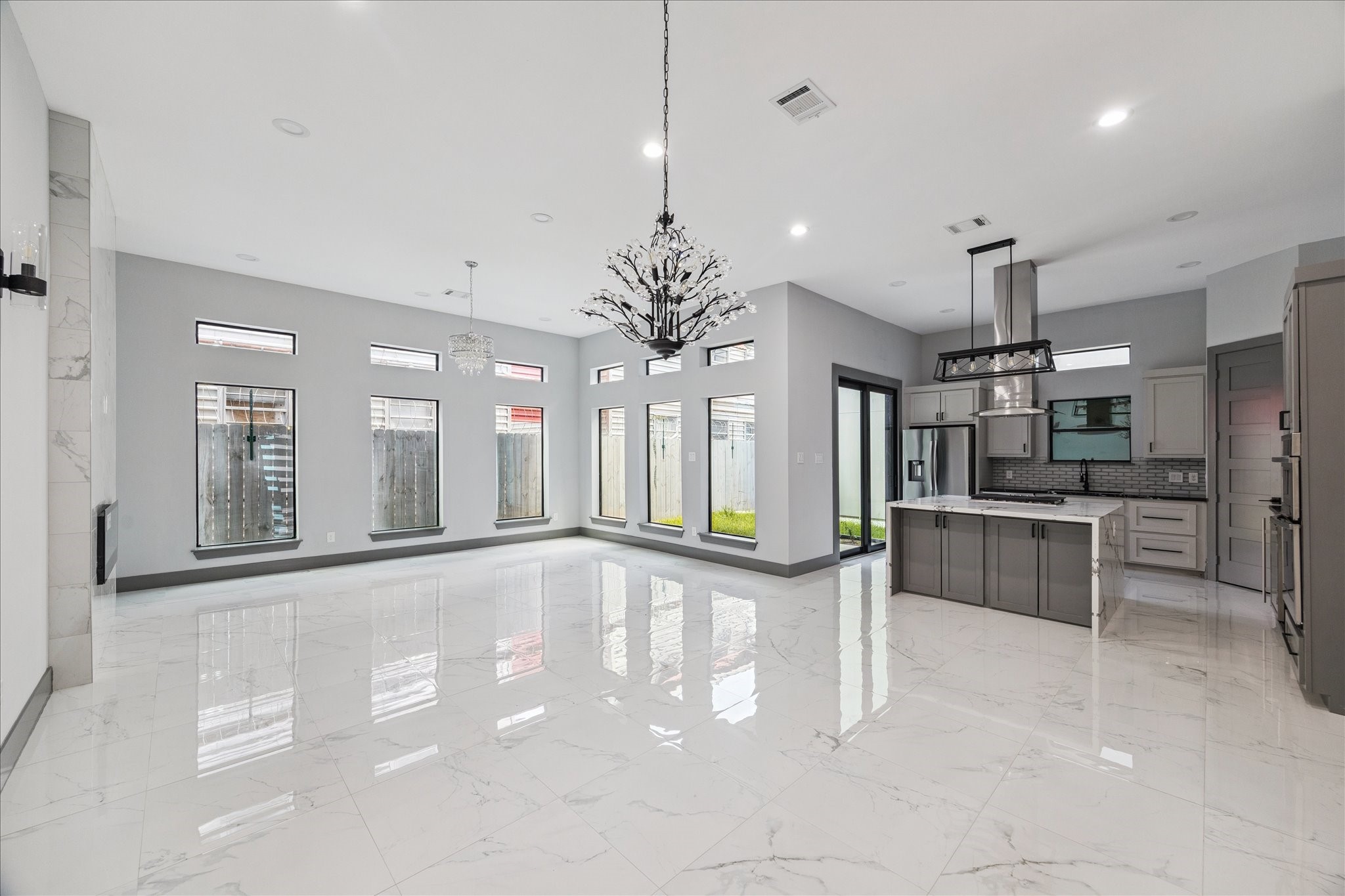 2323 Tuam Street Houston, TX 77004 - Photo 3 of 24 A wall of picture windows brightens the living room, where a tile fireplace adds modern appeal and neutral colors offer design flexibility. Open-concept styling enhances the connection to the kitchen and dining space.