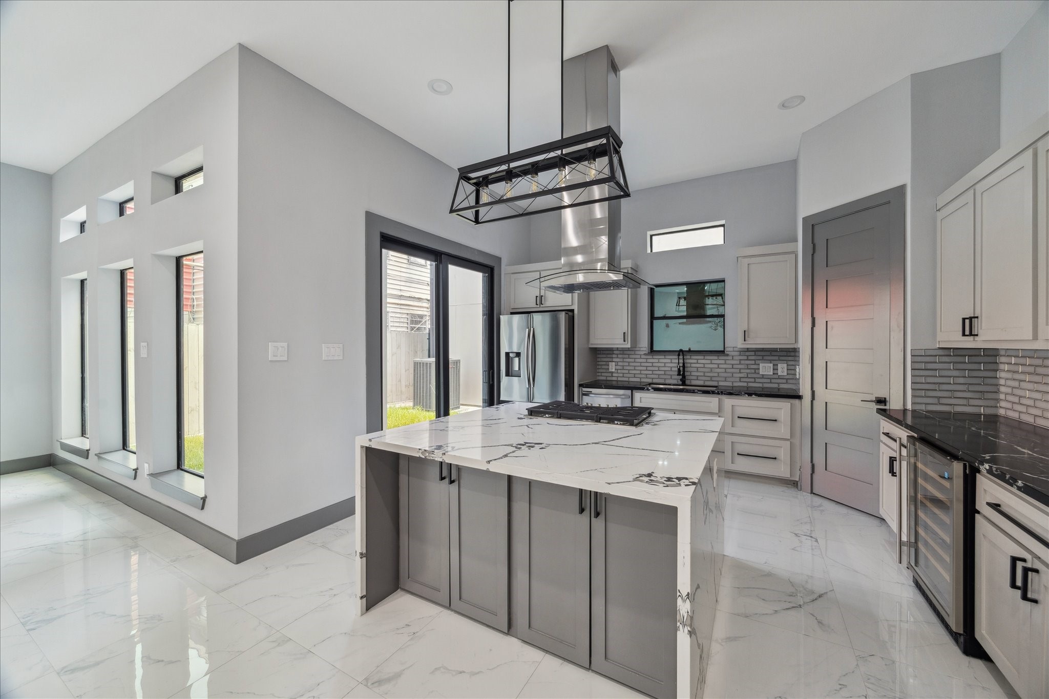 2323 Tuam Street Houston, TX 77004 - Photo 10 of 24 Walls of windows connect the kitchen and living area, creating an easy flow for both dining and entertaining. A spacious island anchors the open layout, while clean finishes and modern details bring style and function together.