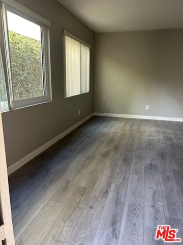 a view of a kitchen with wooden floor and cabinets