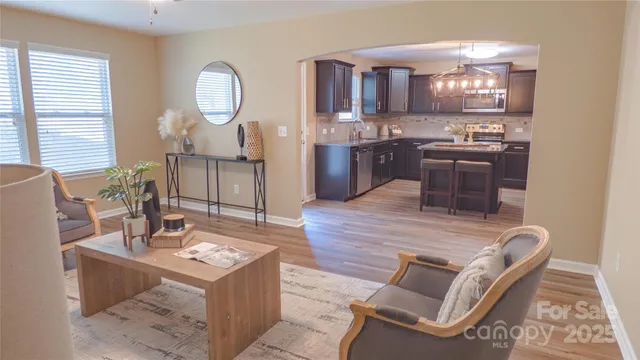 a dining room with wooden floor a chandelier a wooden table and chairs