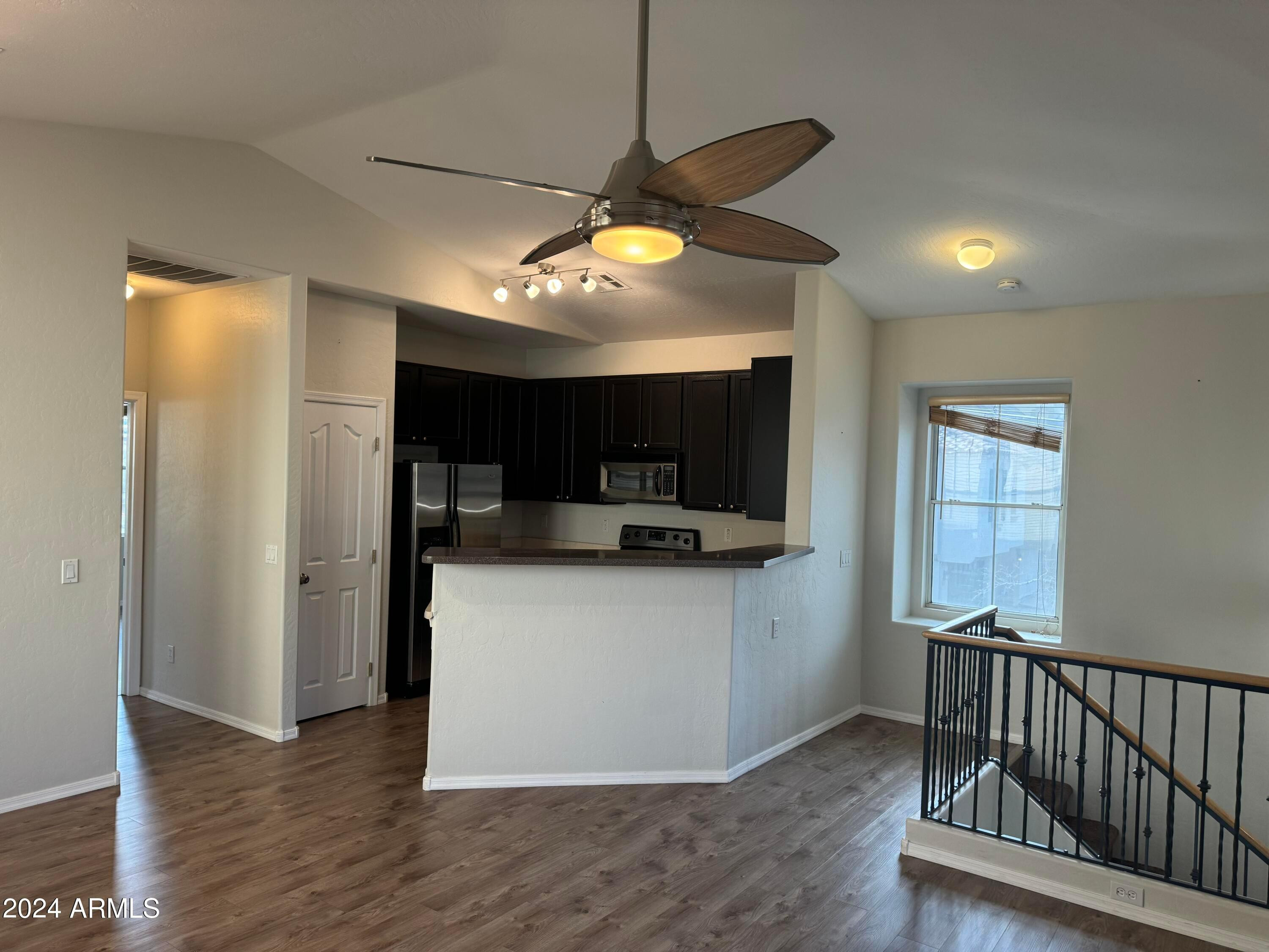 446 North Alder Court Gilbert, AZ 85233 - Photo 16 of 25 a kitchen with stainless steel appliances granite countertop a stove a refrigerator a sink a microwave oven with wooden floor and cabinets