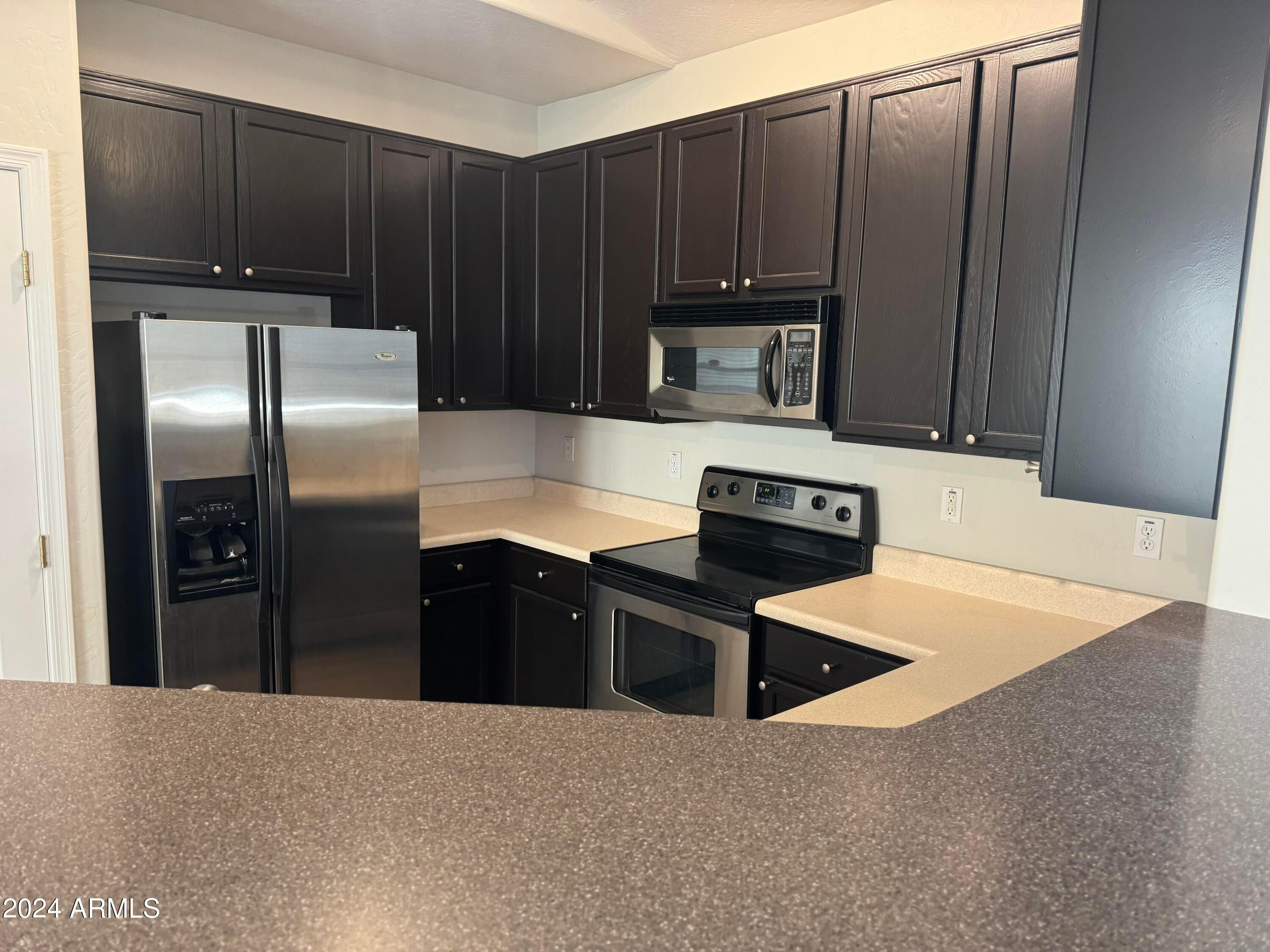 446 North Alder Court Gilbert, AZ 85233 - Photo 6 of 25 a kitchen with kitchen island a counter top space cabinets and stainless steel appliances