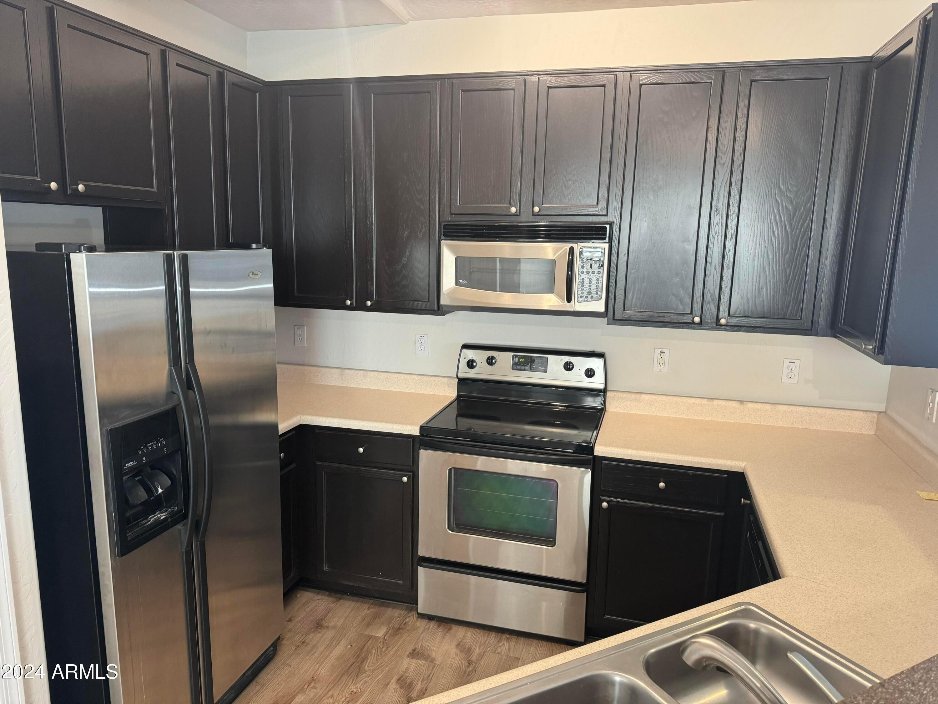 446 North Alder Court Gilbert, AZ 85233 - Photo 7 of 25 a kitchen with granite countertop wooden cabinets and stainless steel appliances