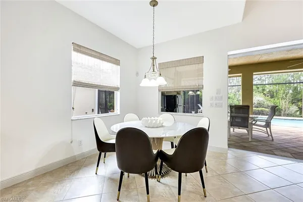 a dining room with furniture a chandelier and window