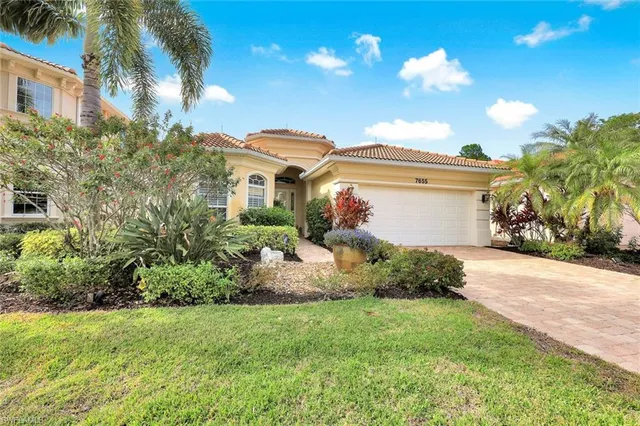 a front view of a house with a yard and potted plants