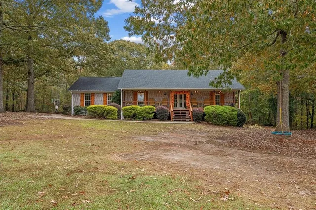 a front view of a house with a yard and trees