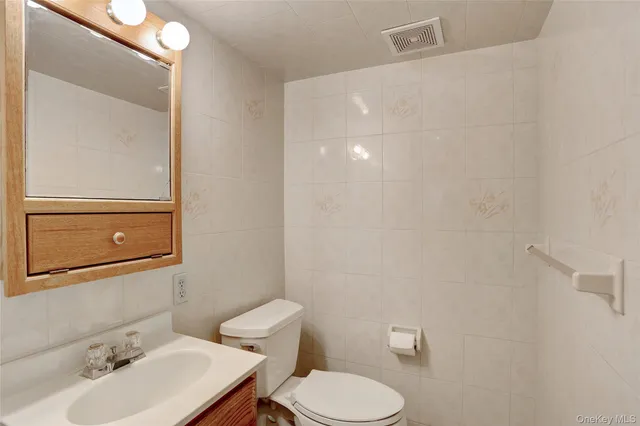 a bathroom with a sink mirror and toilet