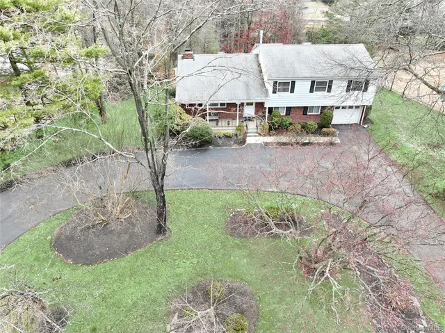 a view of a house with a yard and sitting area