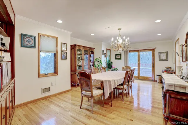 a view of a dining room with furniture a chandelier and wooden floor