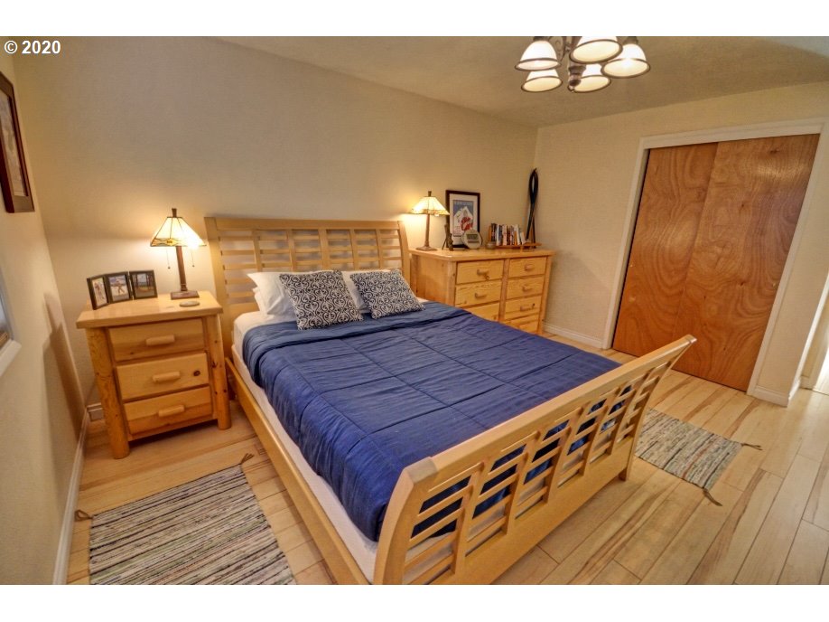 64980 East Pine Tree Way Rhododendron, OR 97049 - Photo 12 of 32 a bedroom with a bed and wooden floor