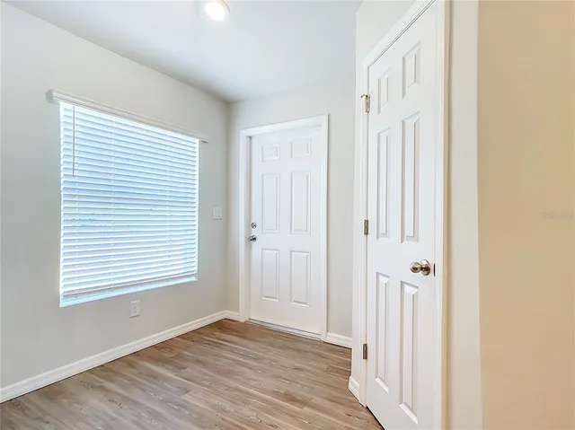 a view of a room with wooden floor and a window