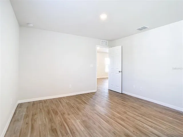 a view of an empty room with wooden floor