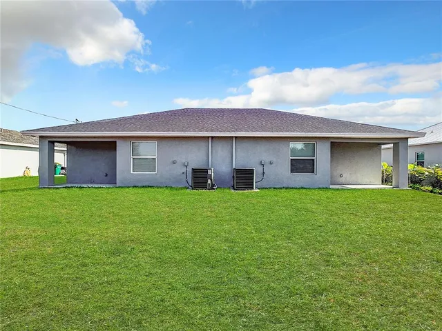 a view of a brick house with a big yard and large trees