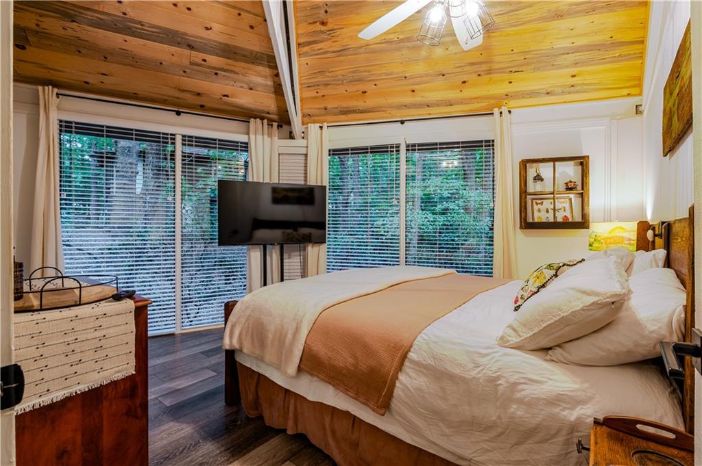 150 Treetopper Circle Big Canoe, GA 30143 - Photo 13 of 26 a bedroom with a bed flat screen tv and a window