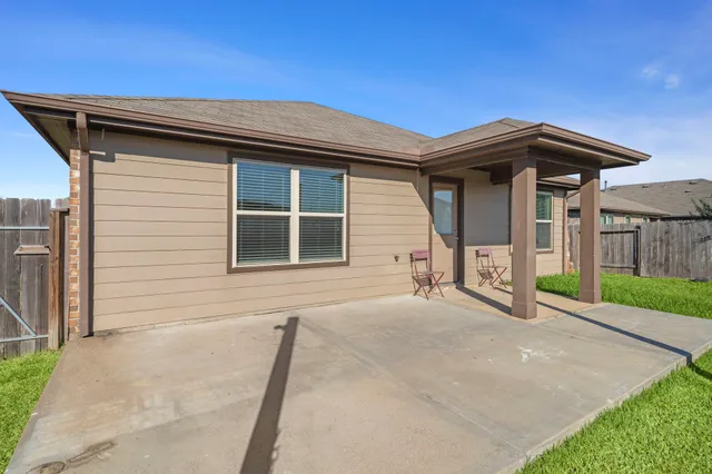 a view of house with backyard and glass windows