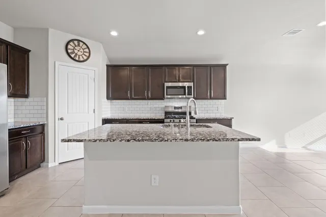 a kitchen with stainless steel appliances granite countertop a sink and a stove