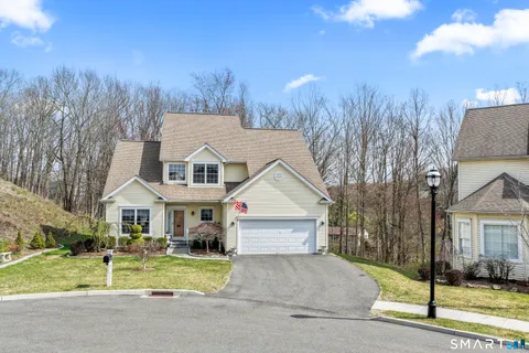 a front view of a house with a yard and trees