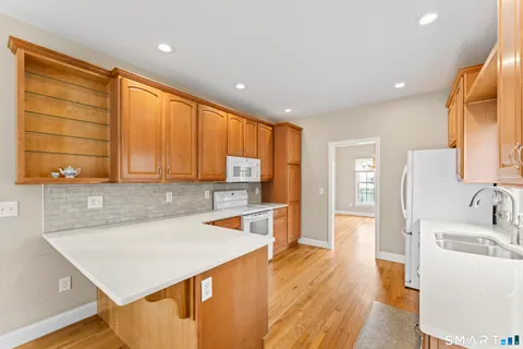 a kitchen with a sink a counter top space appliances and cabinets