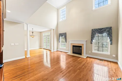 wooden floor fireplace and windows in an empty room