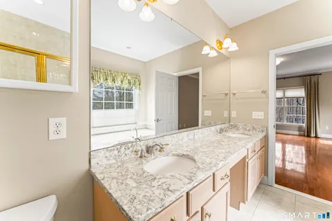 a bathroom with a granite countertop sink and a large mirror