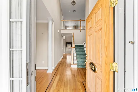 a view of a hallway with wooden floor and staircase