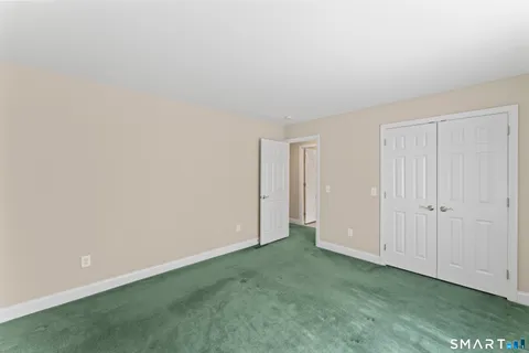 a view of an empty room with closet and a window