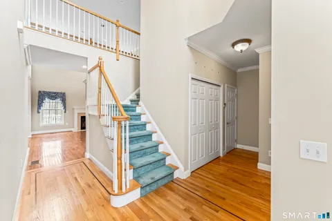a view of a hallway with wooden floor and staircase