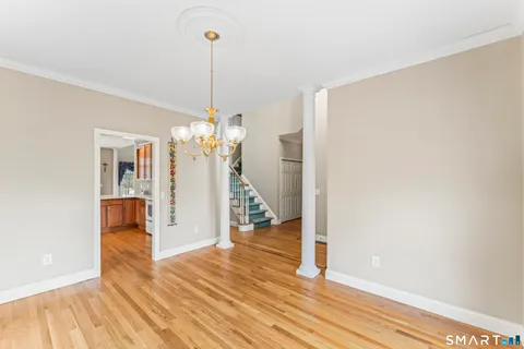 a view of a room with wooden floor staircase and a kitchen