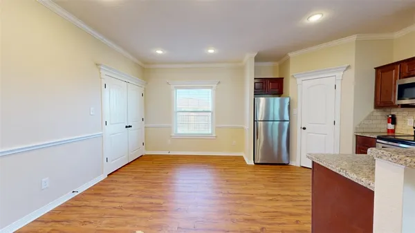 a view of a kitchen and microwave with wooden floor