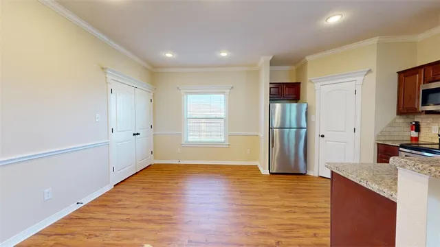 a view of a kitchen and microwave with wooden floor