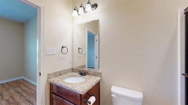 a bathroom with a granite countertop sink toilet and shower