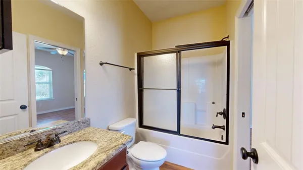 a view of a hallway with wooden floor and closet