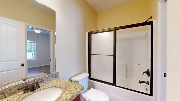 a bathroom with a granite countertop sink toilet and shower