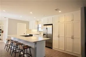 a kitchen with a table chairs refrigerator and cabinets