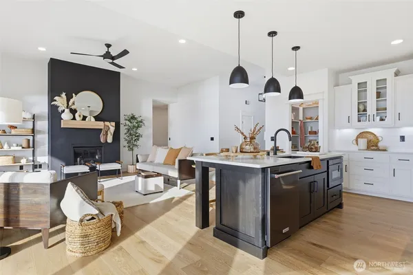 a kitchen with a sink stove and wooden floor