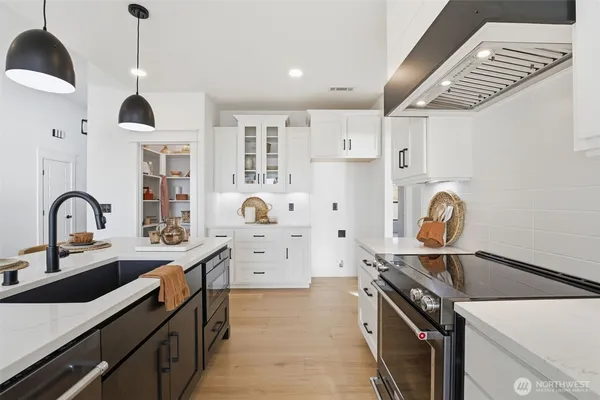 a kitchen with kitchen island a sink appliances and cabinets