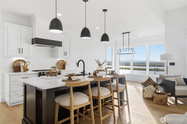 a kitchen with stainless steel appliances a dining table chairs and white cabinets