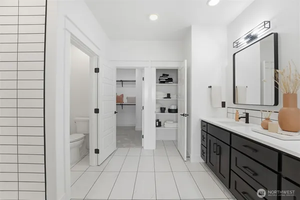 a spacious bathroom with a double vanity sink a mirror and a shower