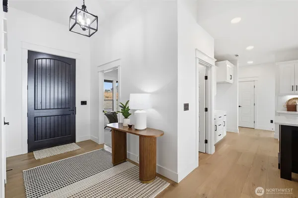 a view of a hallway with bathroom and wooden floor