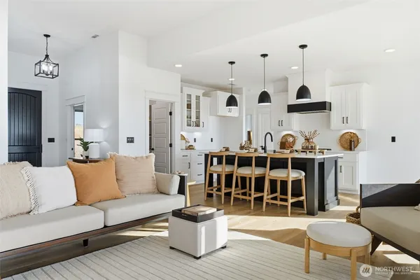 a living room with furniture a dining table and a chandelier