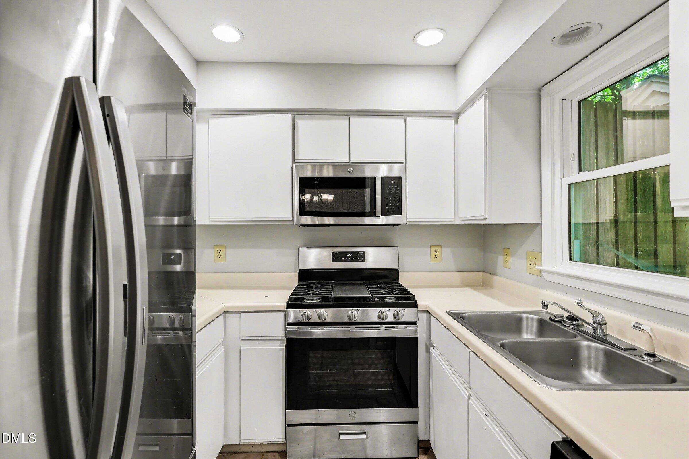 5645 Hamstead Crossing Raleigh, NC 27612 - Photo 11 of 35 a kitchen with stainless steel appliances a stove a sink and a microwave